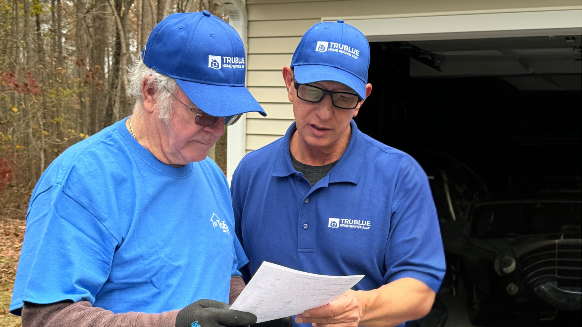 Photo of two TruBlue Home Service Ally team members looking at paper