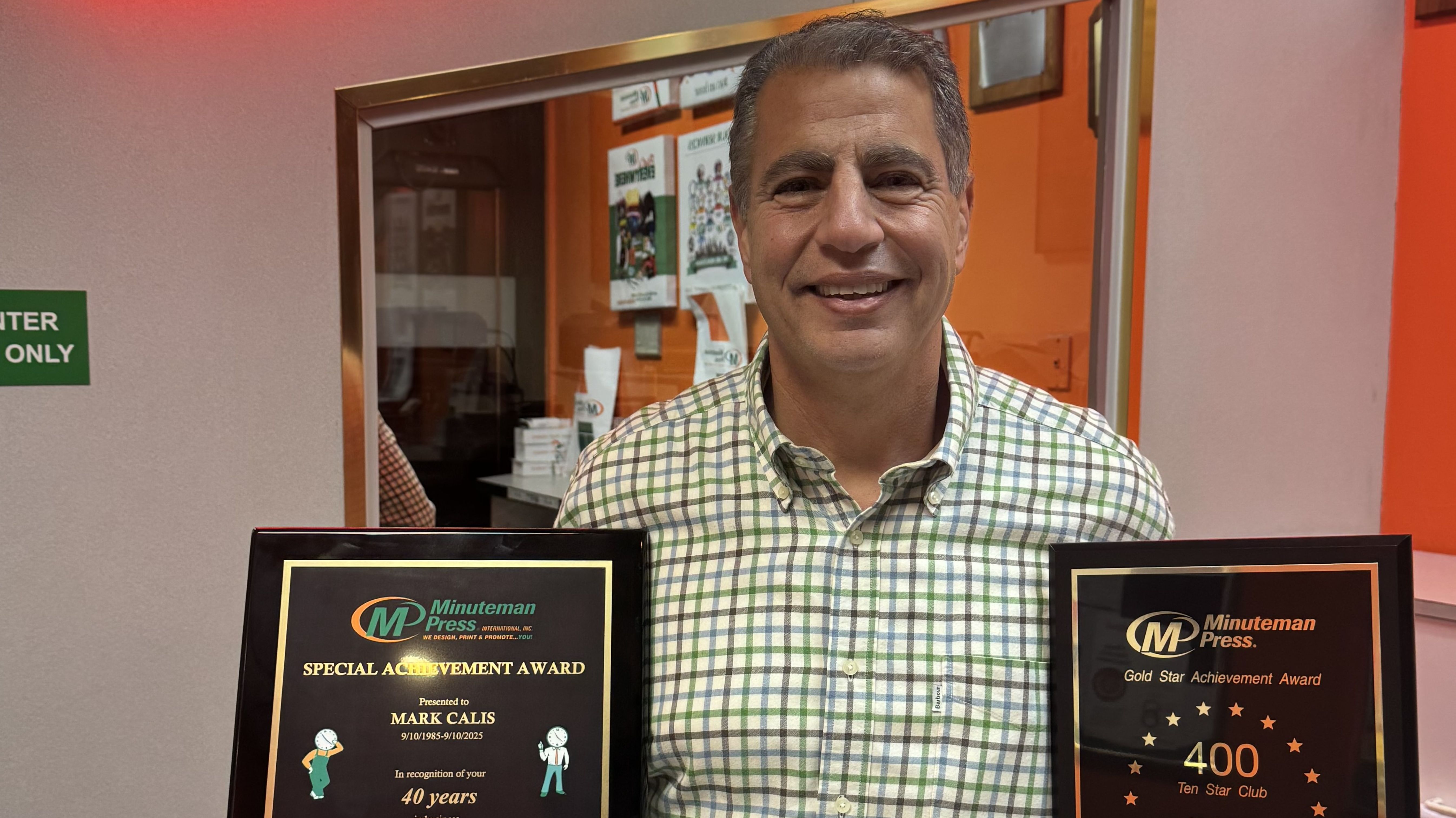 Minuteman Press Franchise Owner Mark Calis proudly displays his 40-Year Special Achievement Award.