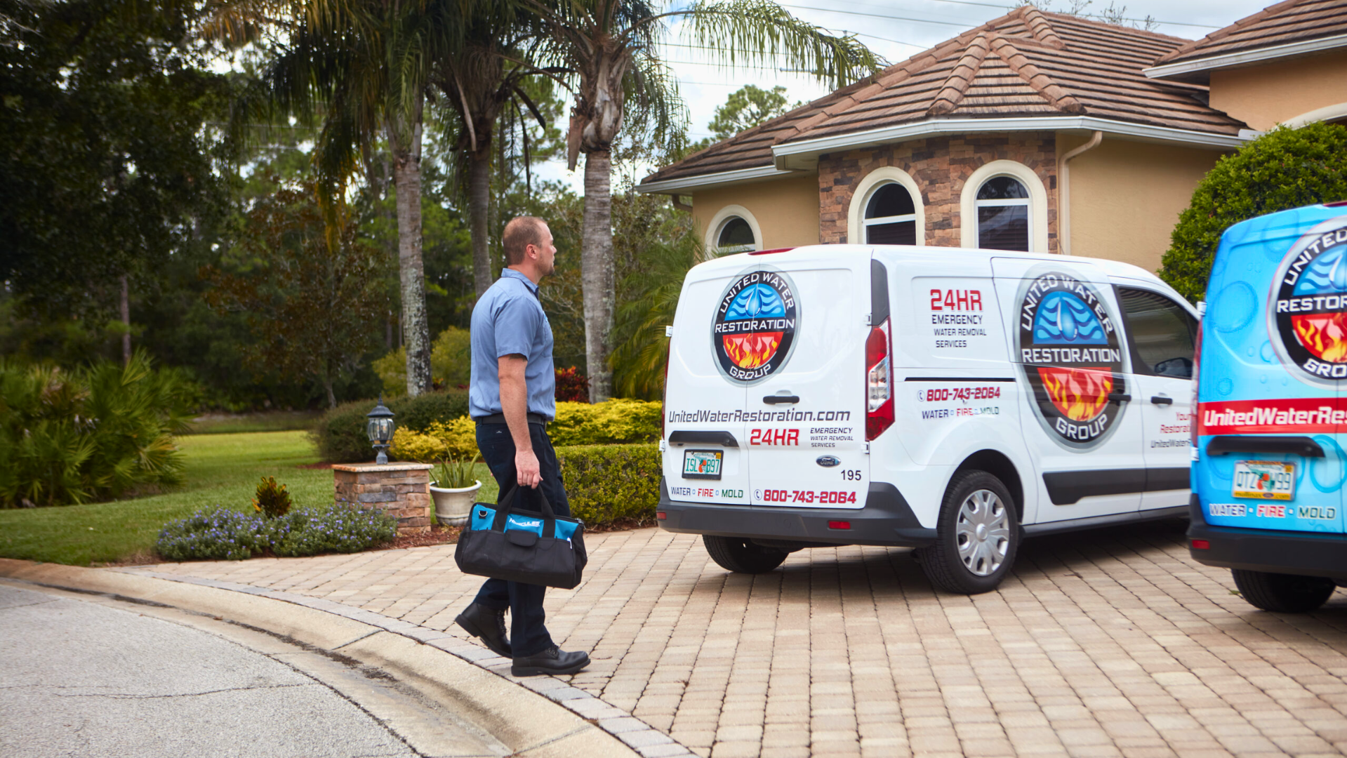 image of united water restoration group entering a home to do water restoration work